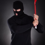 Masked thug or criminal with a crowbar