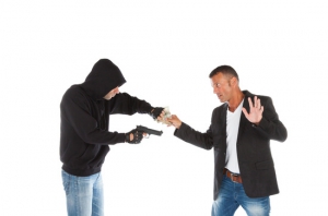 Robber with gun grabbing money from victim